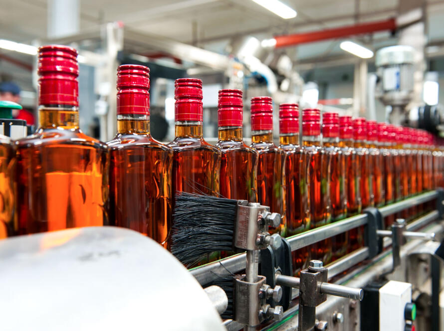 Whisky bottling line with glass bottles being filled and sealed